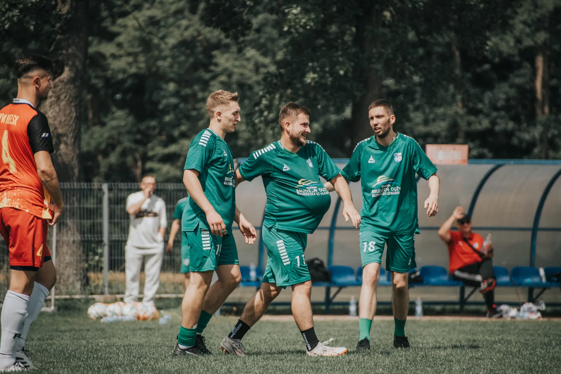Zawodnicy spotykają się przy bramce na boisku.