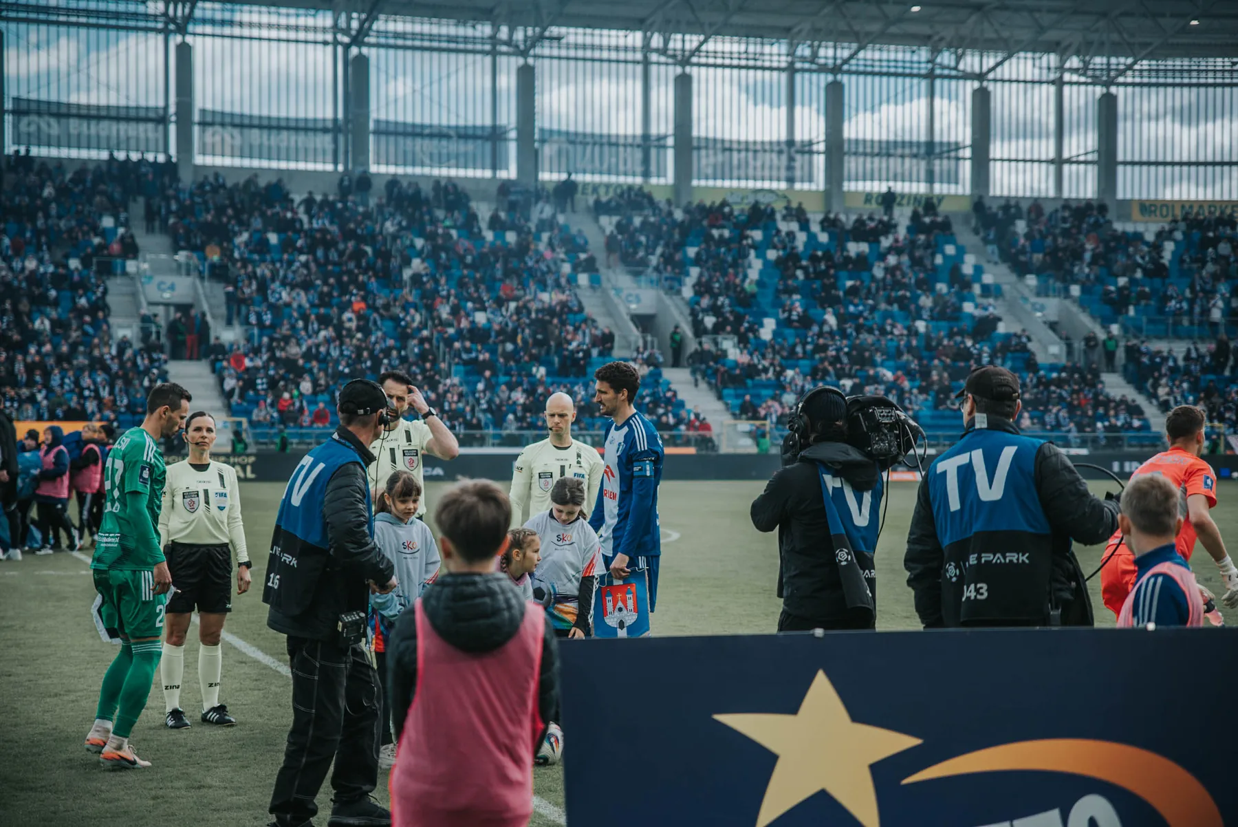 Drużyny wychodzą na murawę stadionu przed meczem.