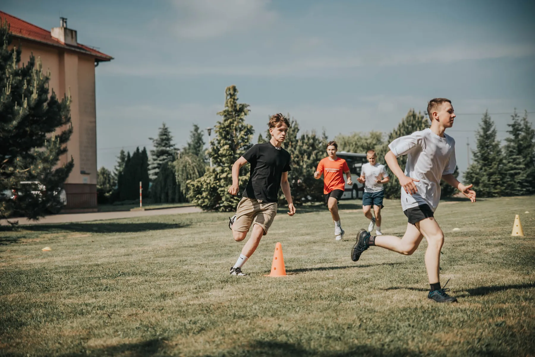 Uczestnicy biegną podczas plenerowej rywalizacji sportowej.