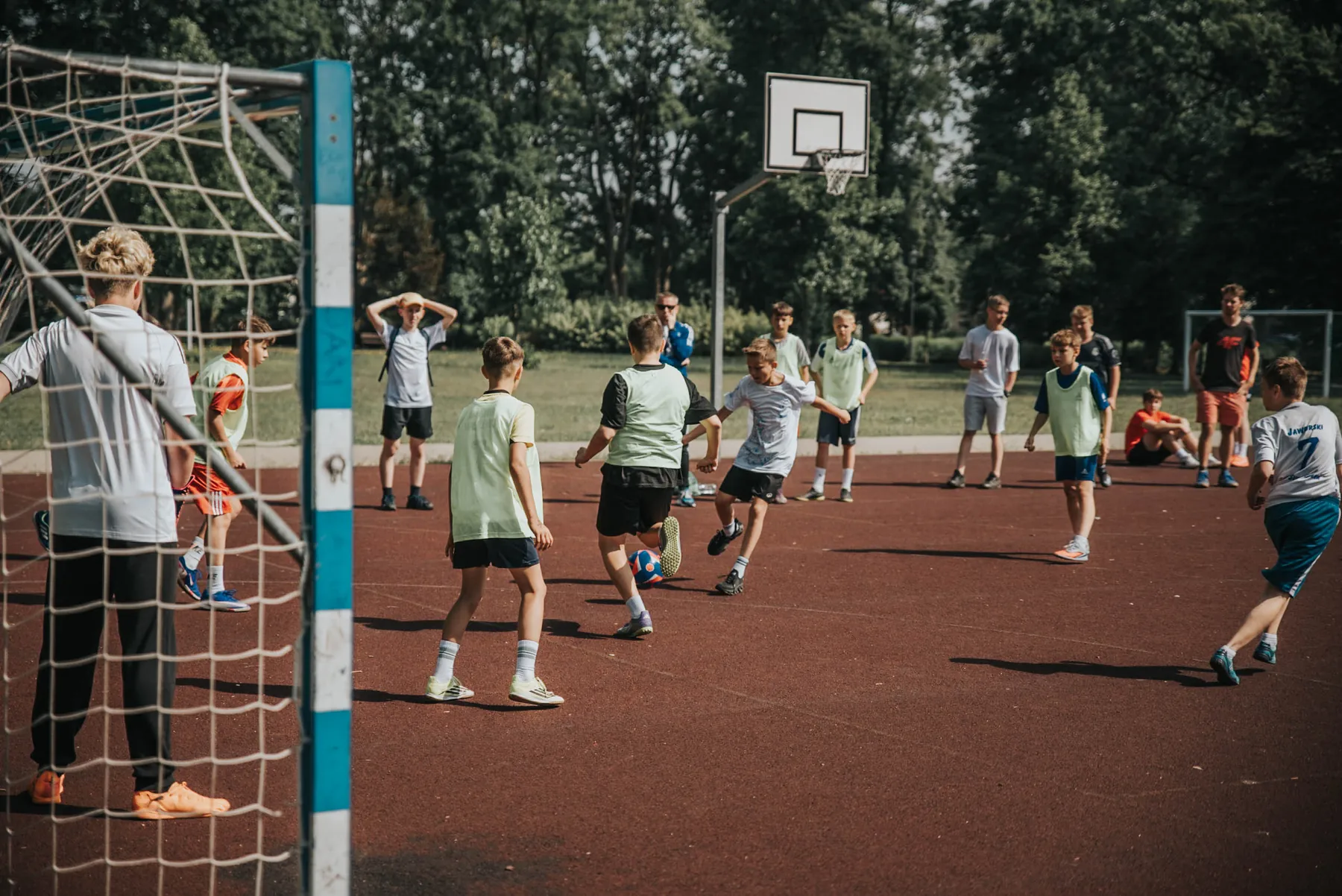 Młodzi sportowcy grają zespołowo na szkolnym boisku.